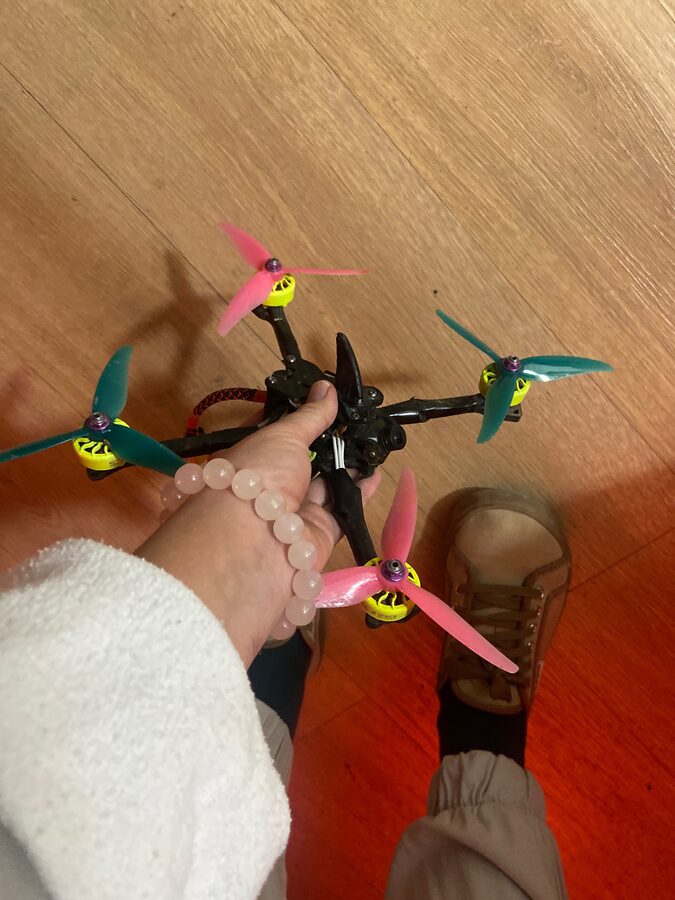 Finished 5-inch FPV quad held in hand, props on, ready to fly