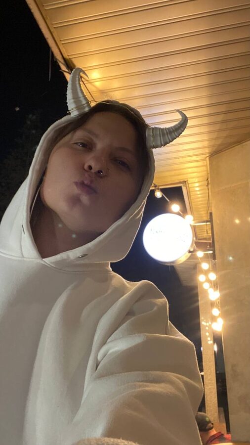 Night selfie in a white hoodie wearing 3D-printed white spiral horns